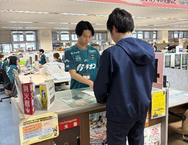 ユニフォームを着用して窓口応対する職員
