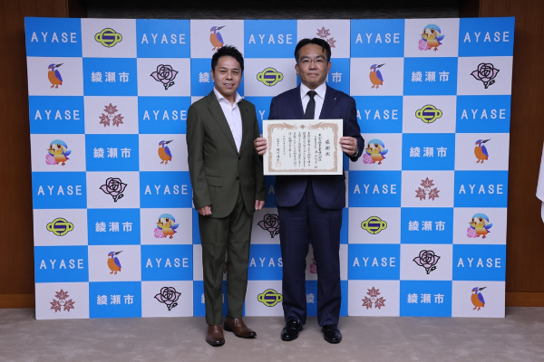 記念撮影の様子(左から栗山智宏社長と橘川市長)