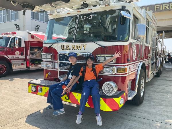 綾瀬市・海老名市少年消防クラブ員が、アメリカの消防車前で交流