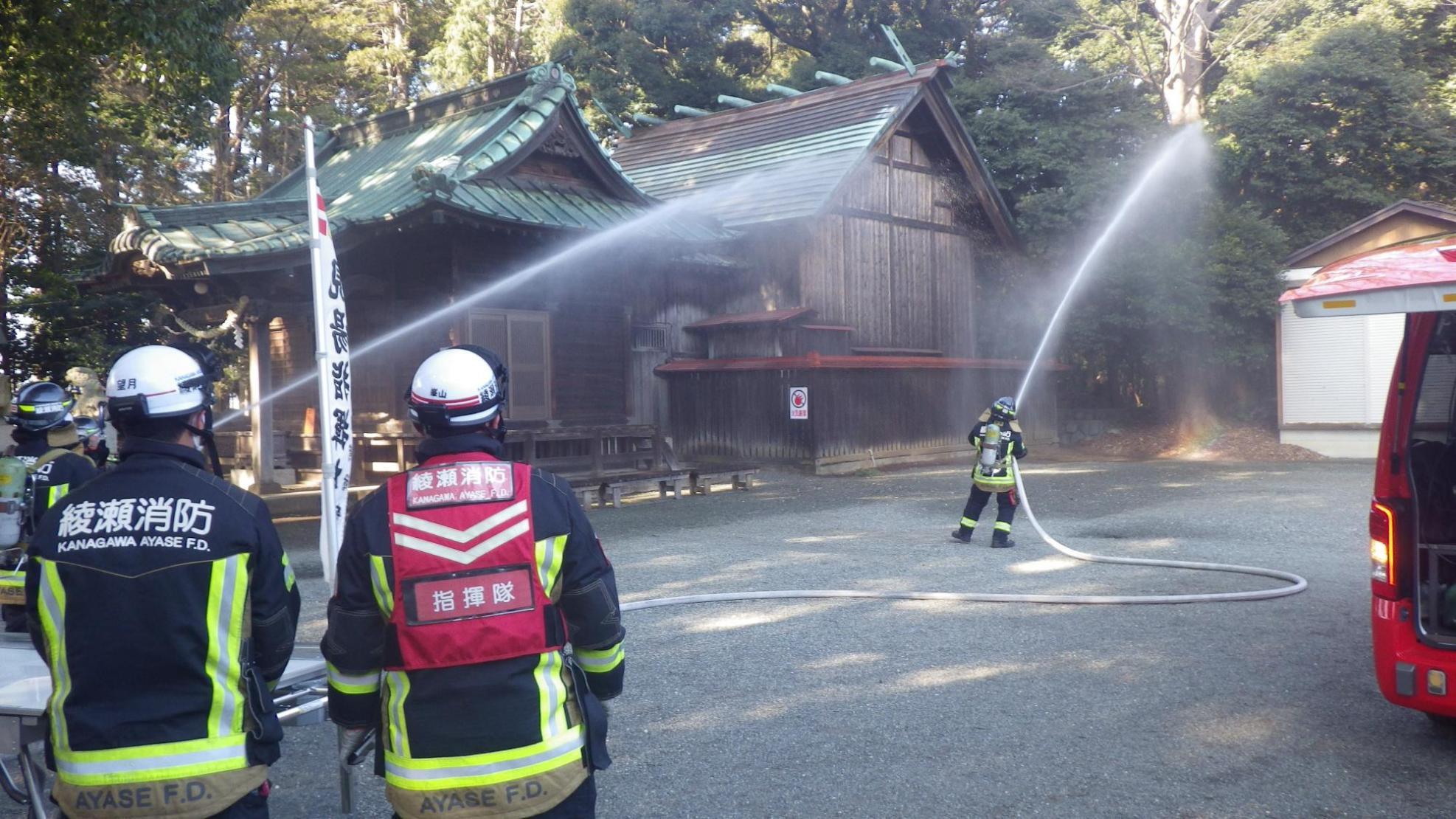 消防隊員の方が建物に向かって放水をしている様子の写真