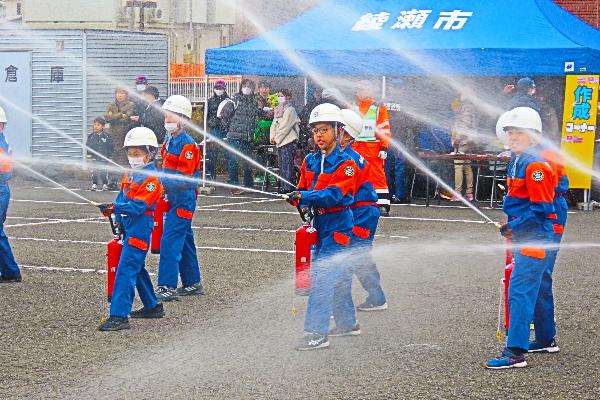 消火器で消火する訓練を披露する少年消防クラブ