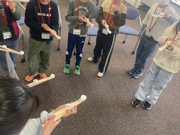 工作したブラジルのけん玉「チクタク」をみんなで遊ぶ様子