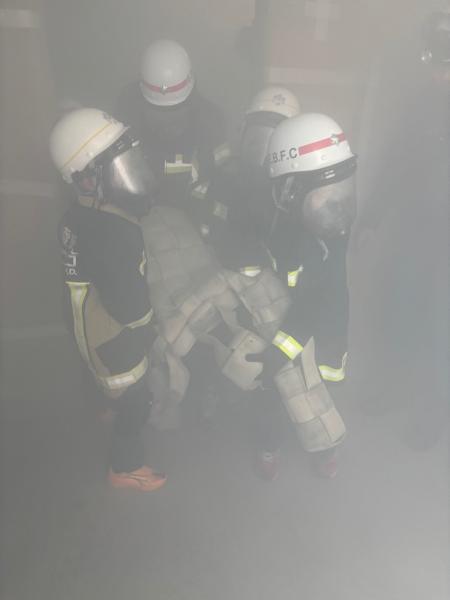 クラブ員たちが煙の中からダミー人形を救出してきた写真