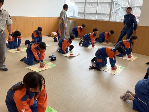 救急隊に胸骨圧迫の方法を教えてもらっている写真