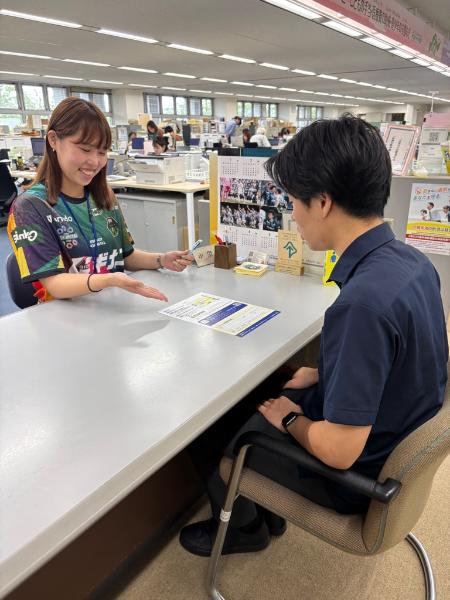 ユニフォームを着用して窓口応対する職員