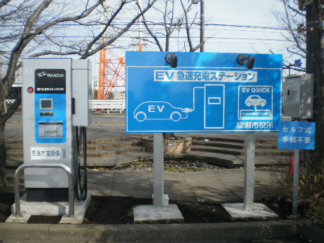 EV急速充電ステーションの看板と急速充電設備の写真