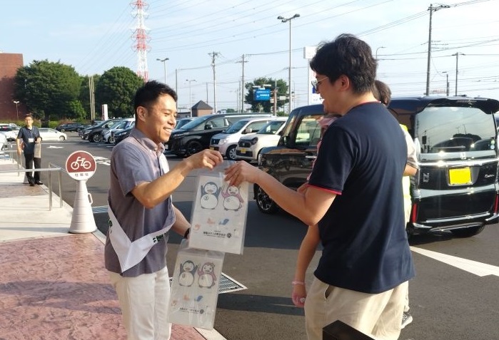 市民課窓口ナンバーモニターの横の画面に「社会を明るくする運動」の案内コマーシャルが流れている写真