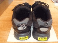 両靴のかかと部分に黄色の反射材のついた早期発見ステッカーがついている写真