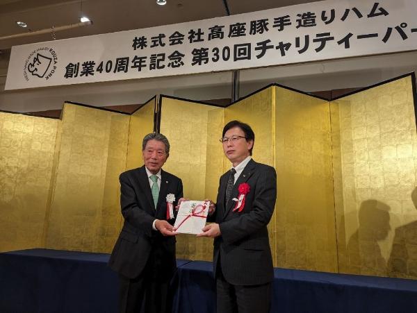 目録贈呈の様子（左から株式会社高座豚手造りハム志澤勝会長、内藤副市長）