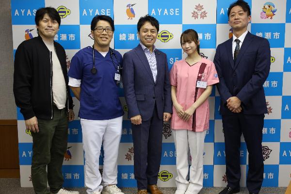 映画「おばあちゃんのかかりつけ医」の表敬訪問の集合写真「左から大橋孝史監督、鈴木拓（ドランクドラゴン）、橘川市長、日向端ひな（高嶺のなでしこ）、きくち総合診療クリニック菊池大和理事長」