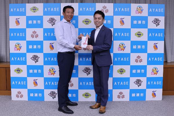 寄付の様子（左から北村均会長、橘川市長）