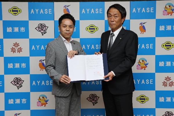 協定締結式の様子（左から橘川市長、佐藤公俊本部長）