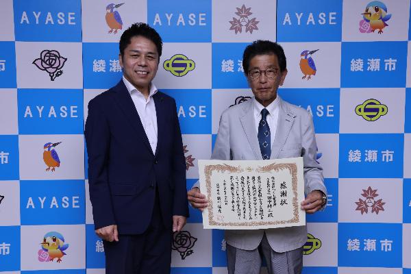 記念撮影の様子（左から橘川市長、田中耕二社長）