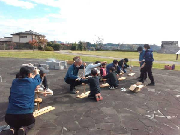 舞切り方を用いた火起こしの様子と神崎遺跡