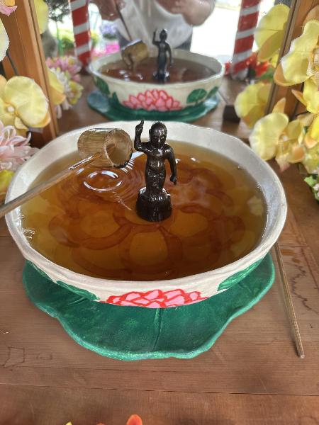 お釈迦さまに甘茶をかけている様子