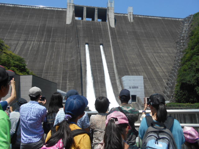 宮ケ瀬ダムから放流されている水を見学している人たちの写真