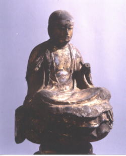 右手を胸の上に挙げ座っている木造地蔵菩薩坐像の写真