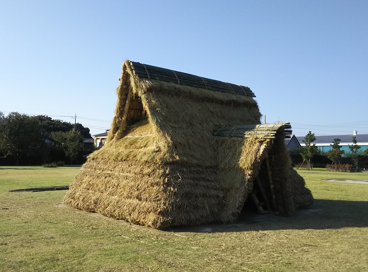 藁で造られた仮設型復元住居を写した写真