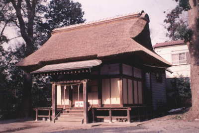 藁ぶき屋根で本殿前に賽銭箱が置かれている熊野社本殿の外観写真