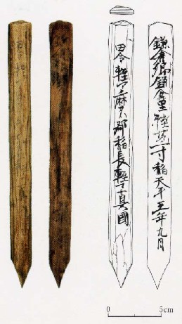 左に出土した2本の木簡の実物とその横に木簡を模写した資料があり、下には大きさを示す縮尺がある写真