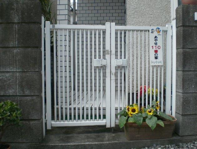 あやせ110番の家と書かれたプレートが付いている、家の門の写真