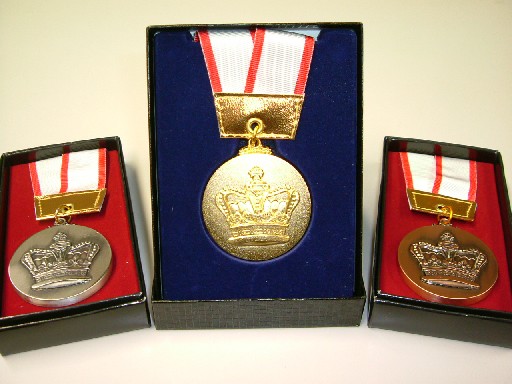中央に青いケースに入った金メダル、左右にそれぞれ置かれている赤いケースに入った銀メダル・銅メダルの写真