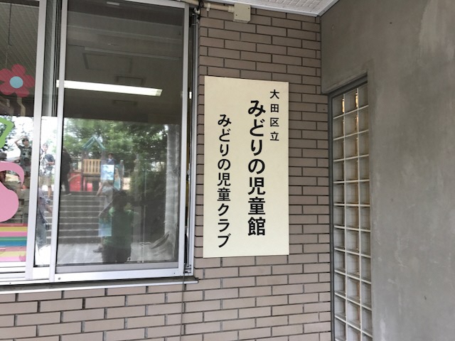 「大田区立 みどりの児童館 みどりの児童クラブ」と書かれた看板が壁に設置されている写真