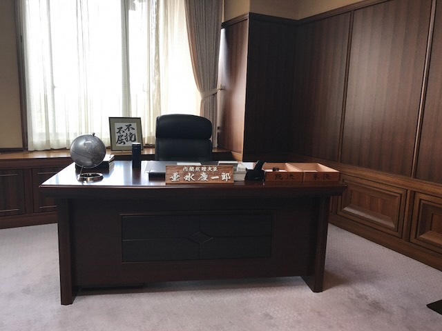 内閣総理大臣 垂水慶一郎の名札が机の上に置かれた内閣総理大臣の机と椅子を写した写真