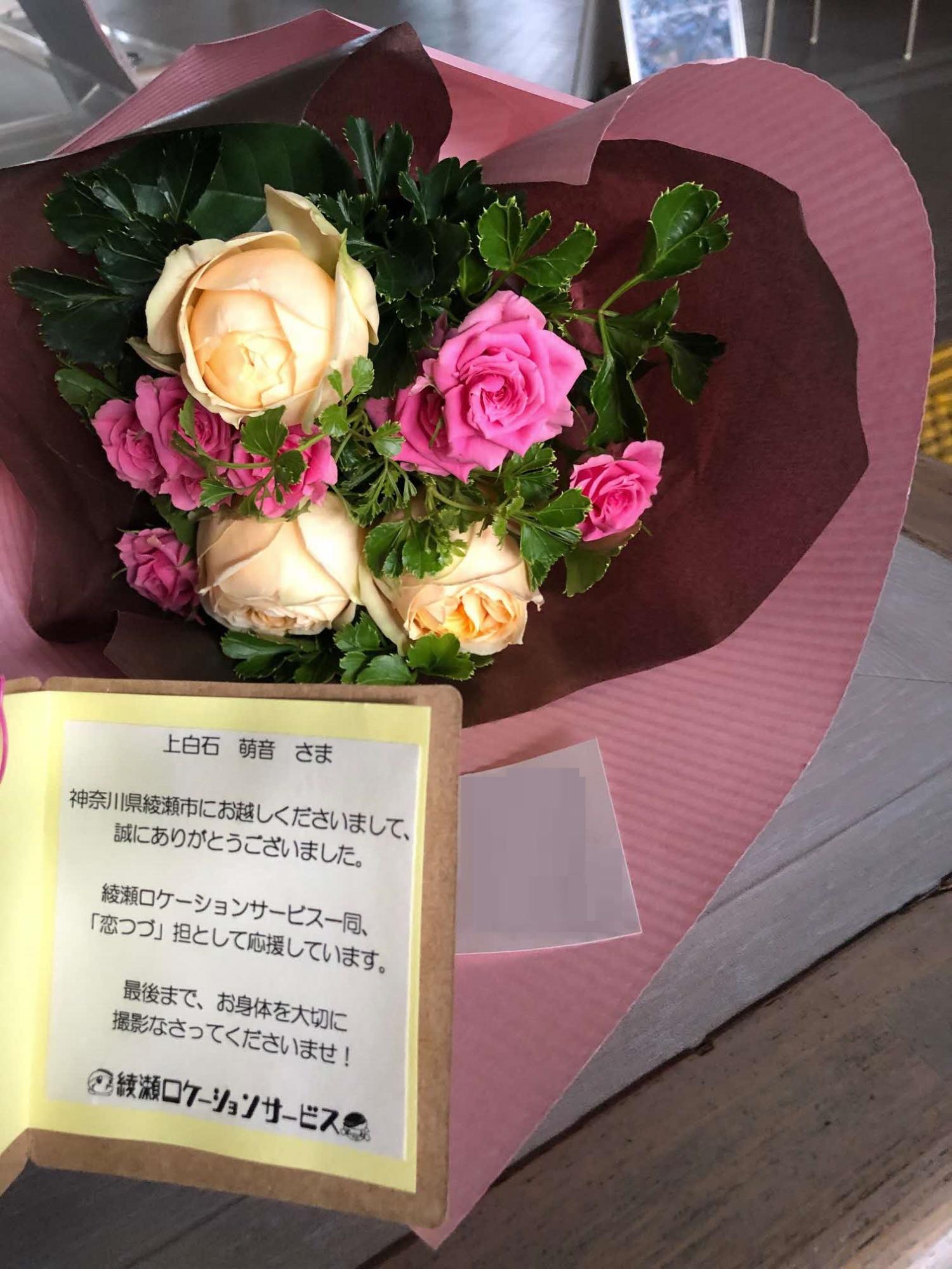 メッセージカードが付いたピンクと白のバラのブーケの写真