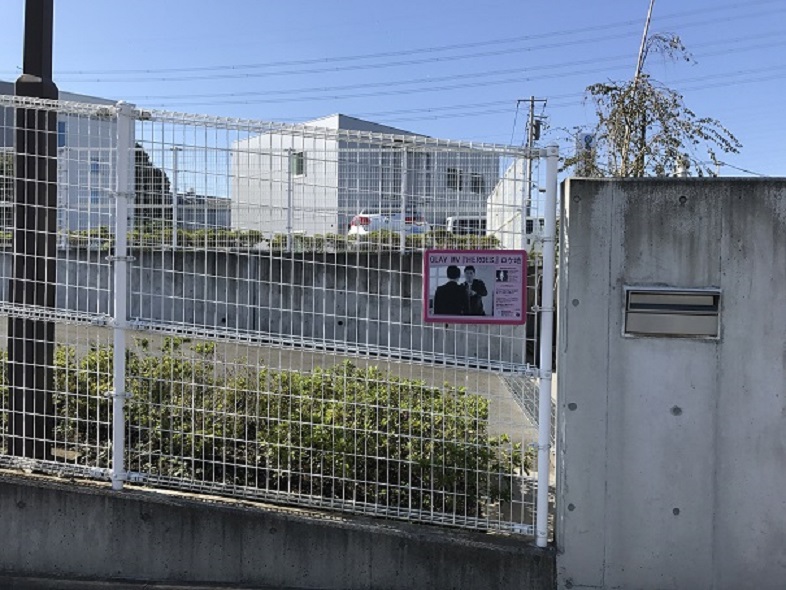 斎藤樹脂工業のフェンスにロケ地看板が掲げられている写真