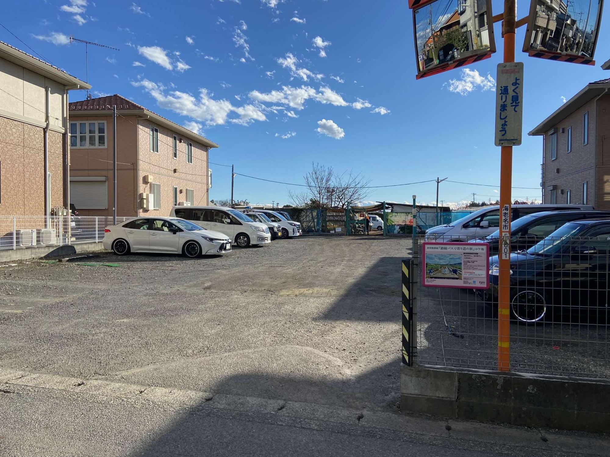 駐車場のフェンスにロケ地看板が取り付けられている様子の写真