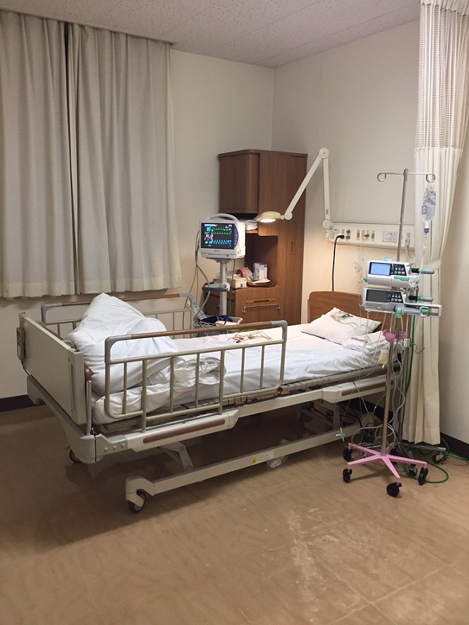 モニターや点滴台がある病室内のベッドを写した撮影風景の写真