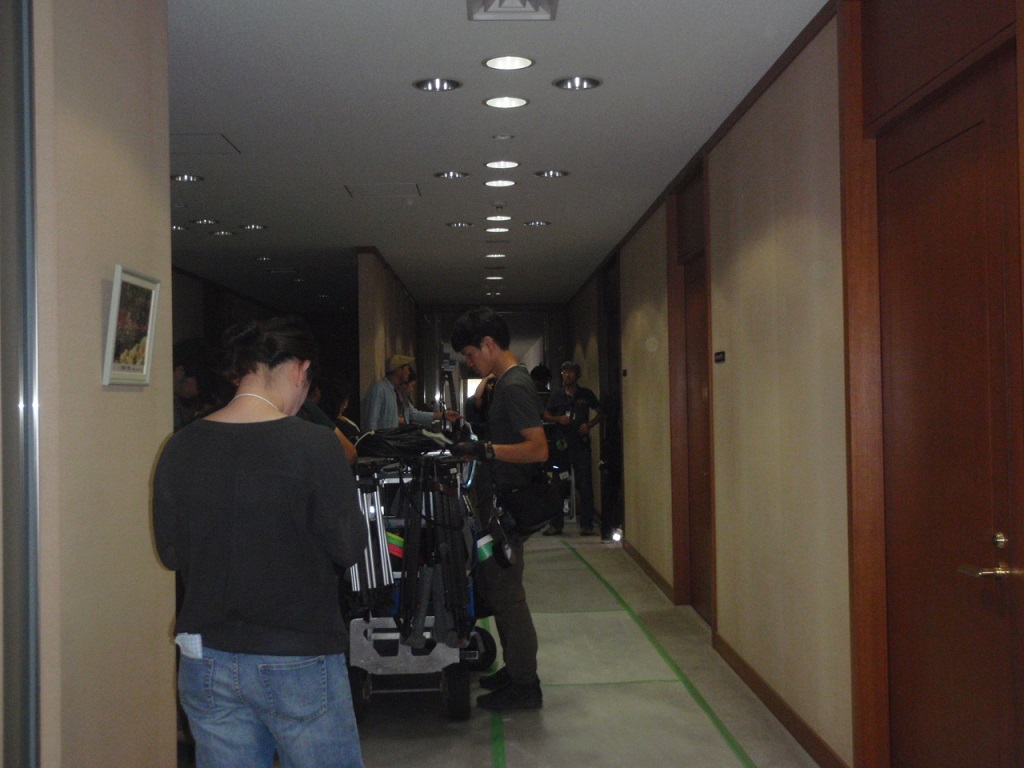 廊下に撮影機材が置かれスタッフの方々が作業をしている様子の写真