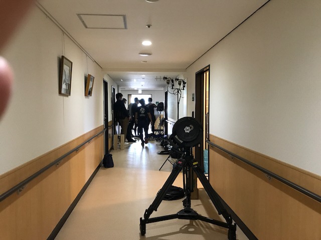 長い廊下の奥の部屋で撮影をしている所を廊下の手前側から写した写真