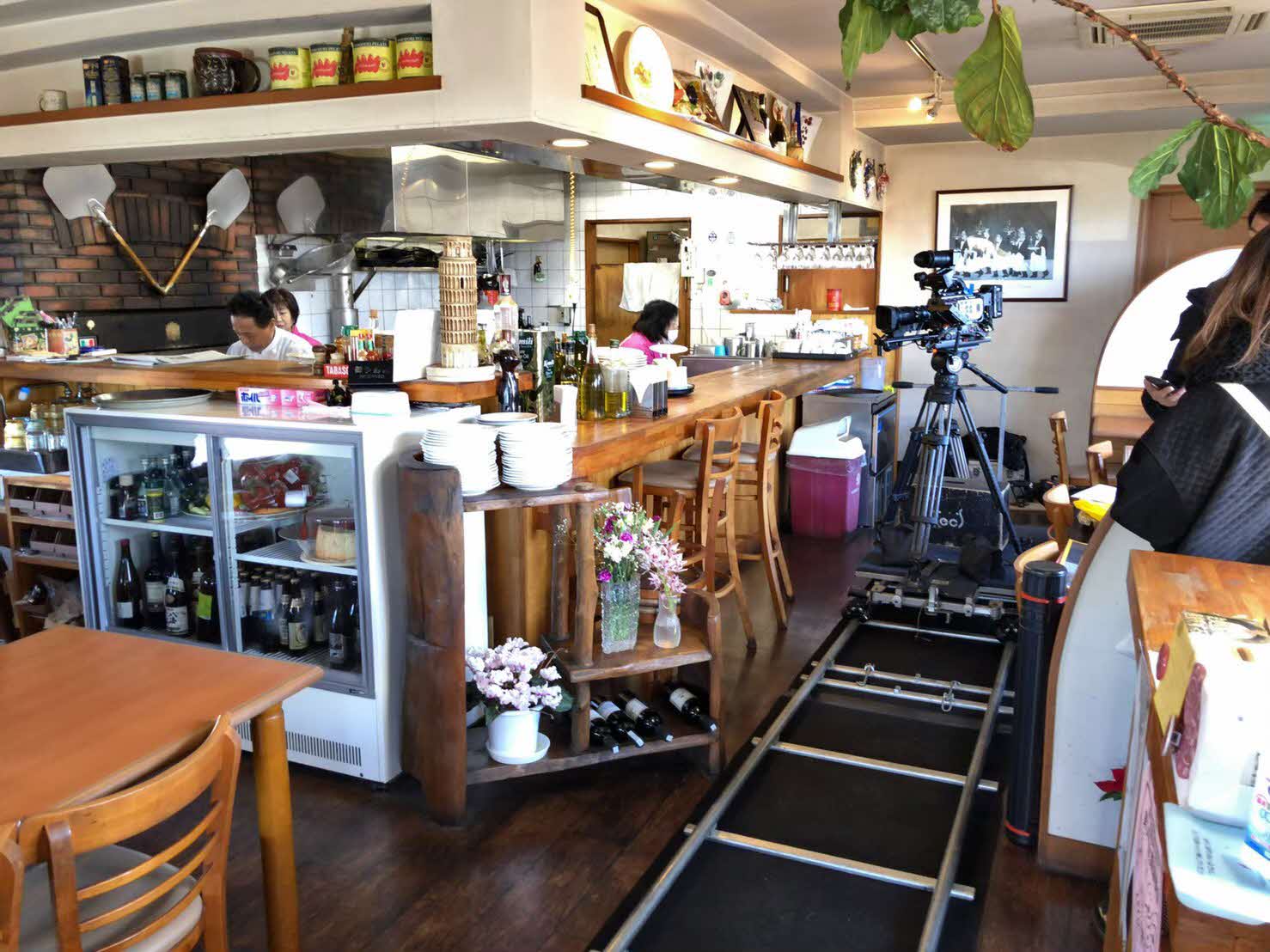 イタリアンレストランバフェットの店内に撮影用のカメラとカメラの高さを固定したまま動かすためのレールが敷かれている写真