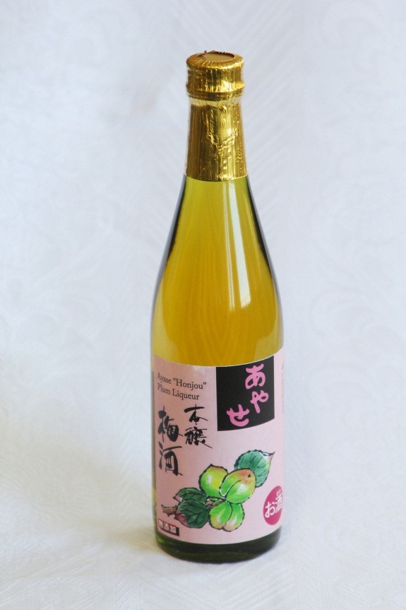 梅の実のイラストが描かれたピンク色のラベルが貼られている梅酒の瓶の写真