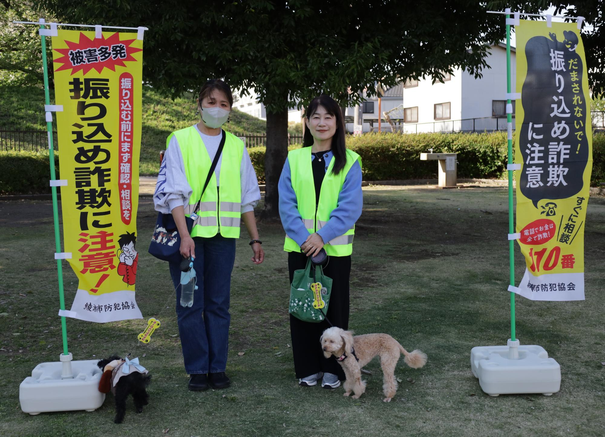 振り込め詐欺の旗と一緒に記念撮影するボランティア