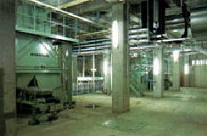 柱と柱の間に大きな機械が置いてある浄水管理センター内の写真