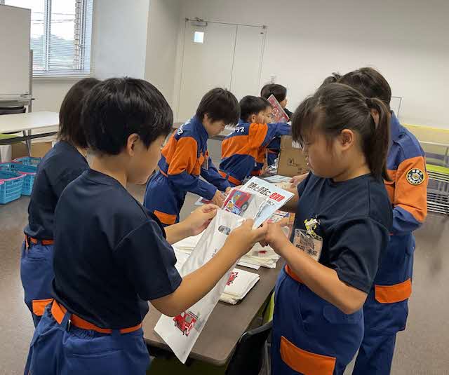 パンフレットなどの防火啓発物品を詰め込むクラブ員