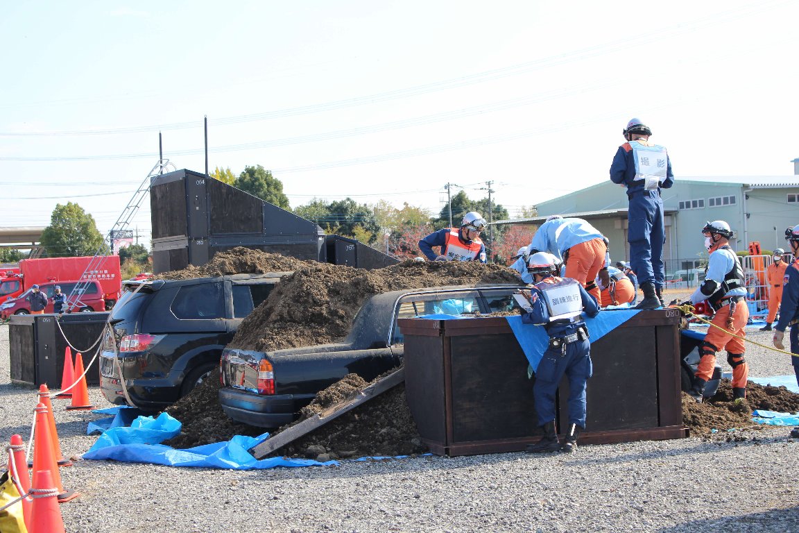 土砂に埋まった乗用車を使って救出の訓練を行っている消防の方々の写真