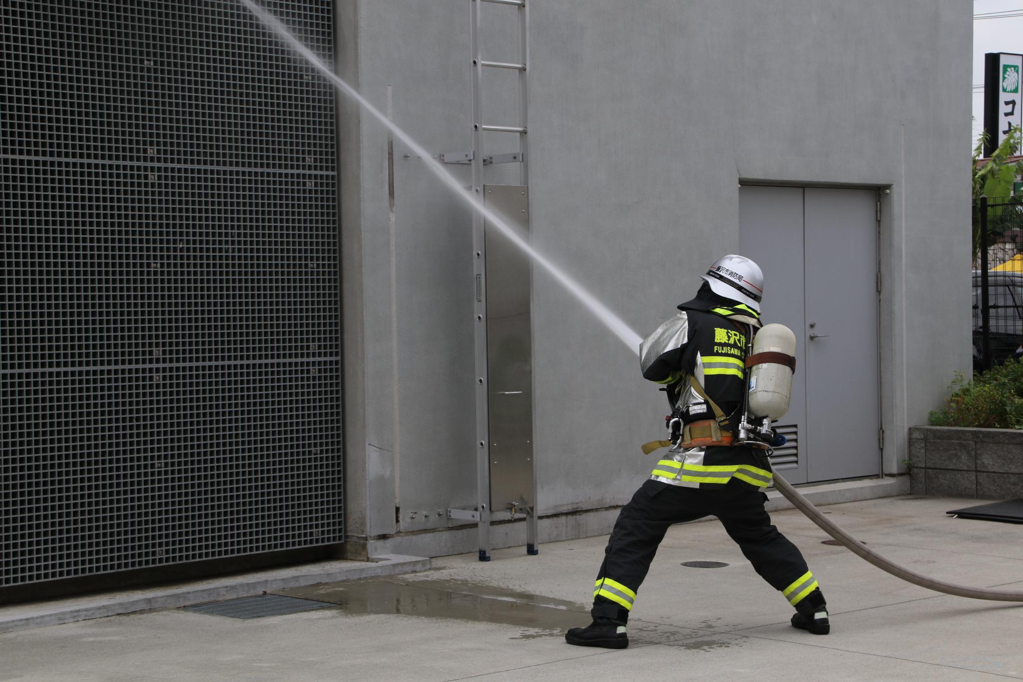 藤沢市消防局の消防隊員が放水している写真