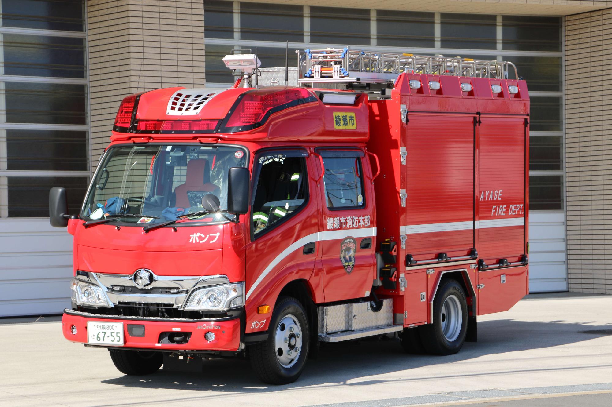 赤い車体の上にはしごを載せており、左右後方にシャッターがついている消防ポンプ自動車の写真