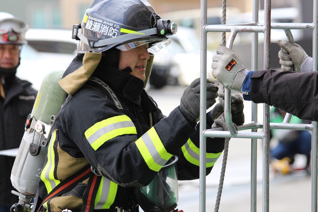 三連はしごを操作している隊員の写真