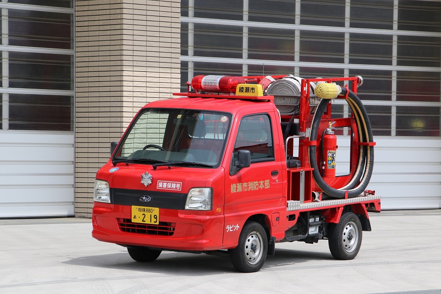 赤い車体の荷台部分にホースや消化器などが搭載されている全自動小型動力ポンプ付軽消防自動車の写真